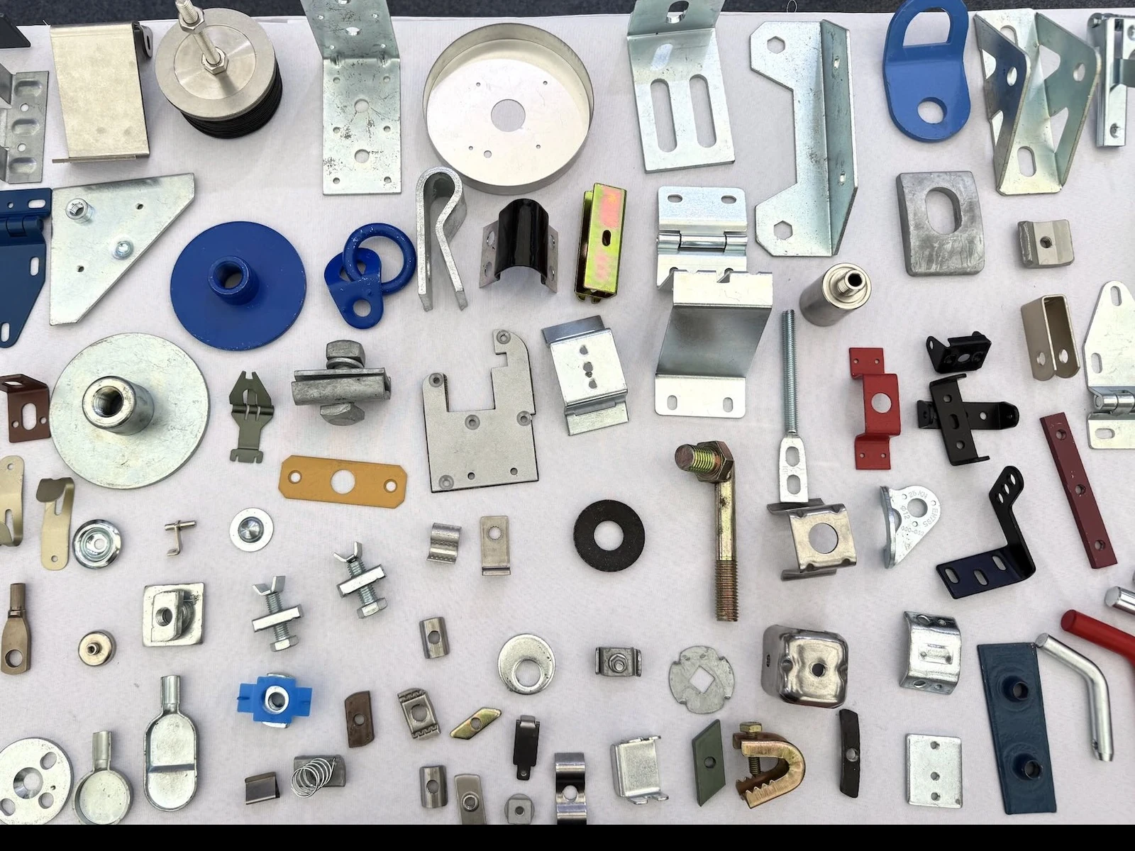 A selection of formed and stamped metal components displayed together.